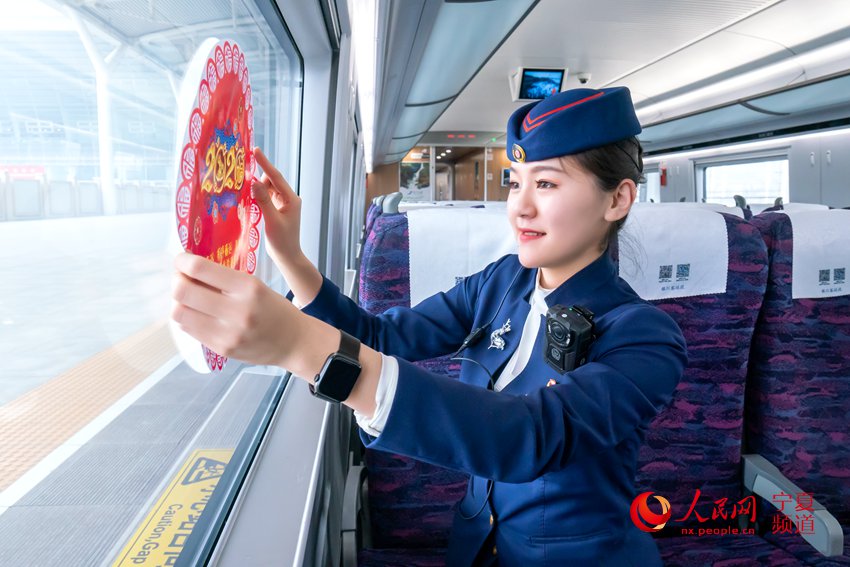 春運首日，銀川至中衛南C8203次列車乘務人員粘貼窗花裝扮高鐵列車