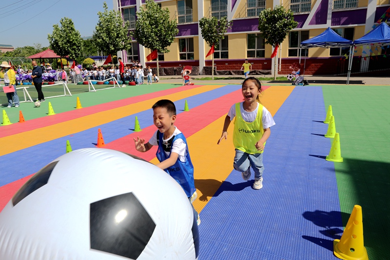 幼儿园的萌宝们正在体验足球带来的快乐。吴军摄