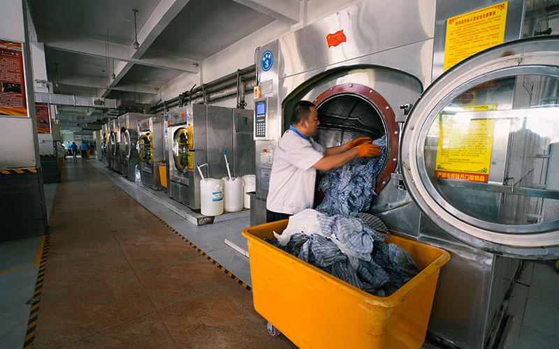 洗涤工们正在对清洗、烘干后的卧具进行装车。谷天朔摄