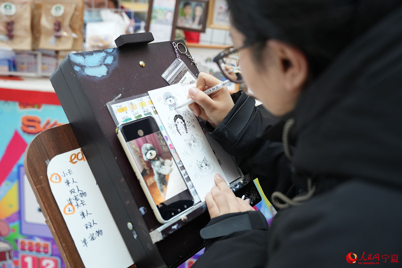 “新年奇趣市集”手艺人正在绘画。人民网记者 梁宏鑫摄