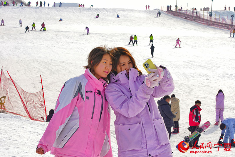 游客在滑雪场自拍合影留念。人民网记者 梁宏鑫摄