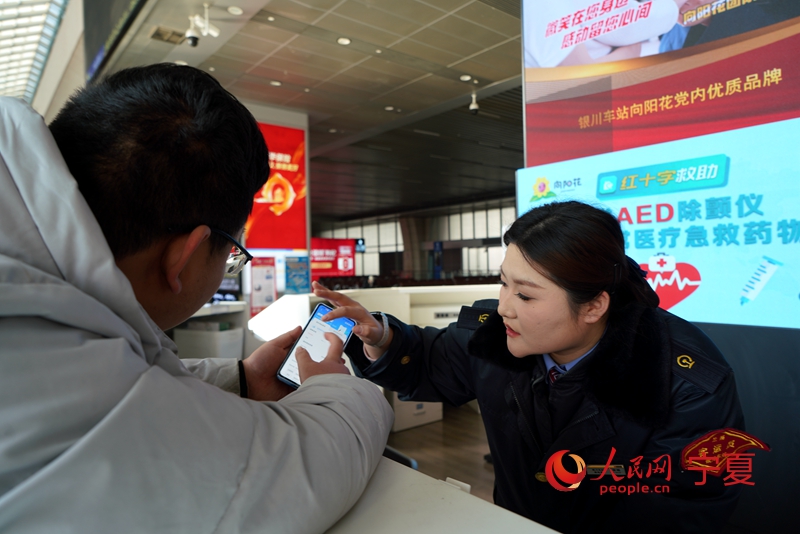 银川火车站工作人员正在引导旅客乘车。人民网记者 梁宏鑫摄