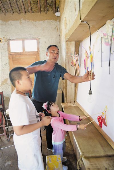 <p>    小游客在上梁村的傳統文化室體驗皮影戲。</p>